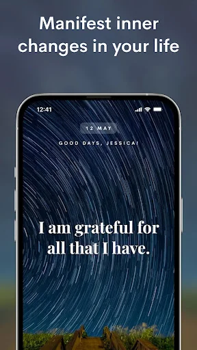 Gratitude affirmation 'I am grateful for all that I have' displayed on star trail background in manifestation app